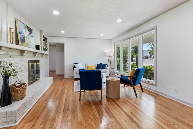 interior space featuring a fireplace, a textured ceiling, and light hardwood / wood-style flooring