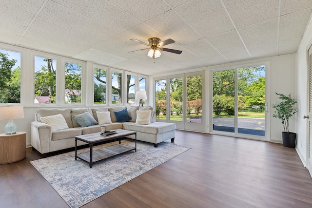 sunroom / solarium with ceiling fan and a drop ceiling