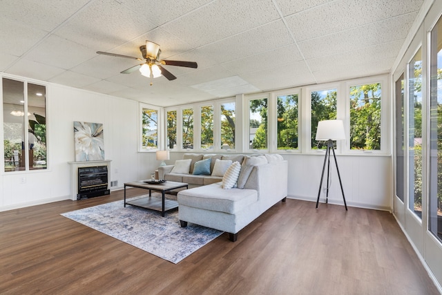 living room featuring a drop ceiling, hardwood / wood-style flooring, and ceiling fan