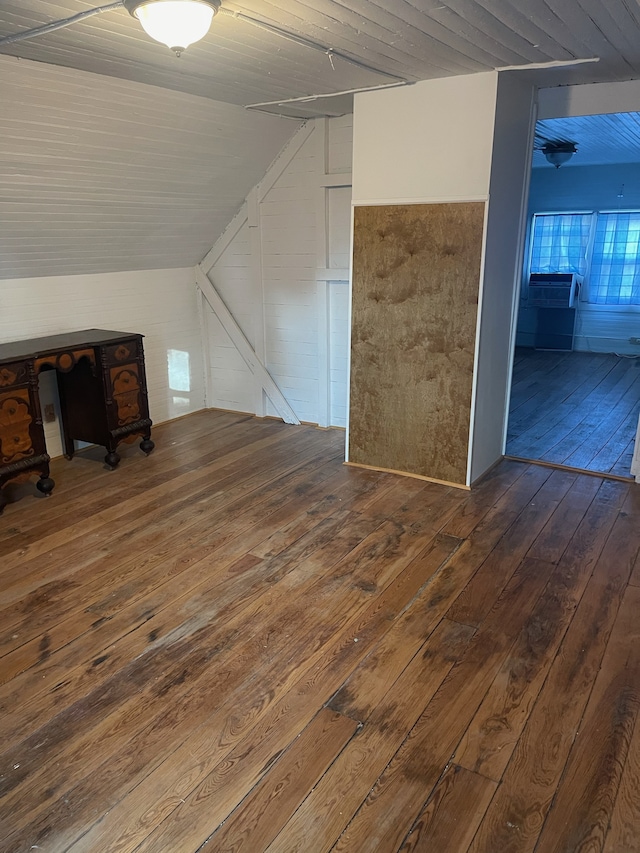 additional living space featuring dark wood-type flooring and vaulted ceiling