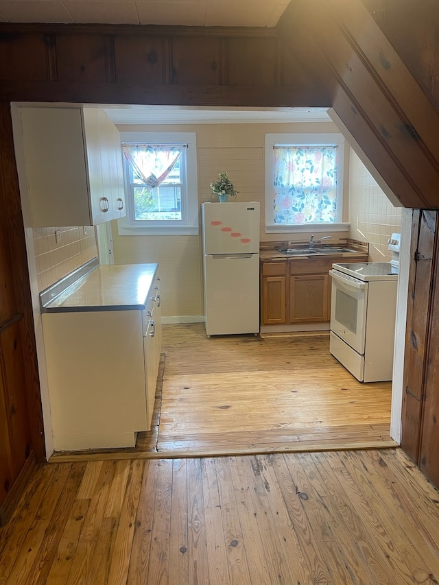 kitchen with backsplash, sink, light hardwood / wood-style floors, and white appliances