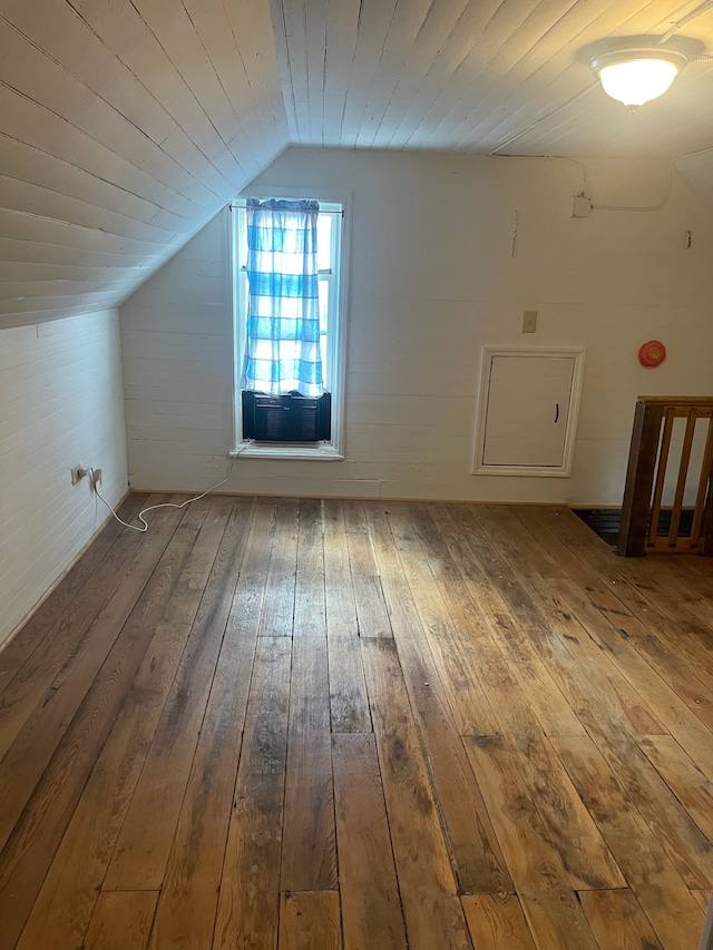 bonus room featuring cooling unit, vaulted ceiling, and hardwood / wood-style flooring