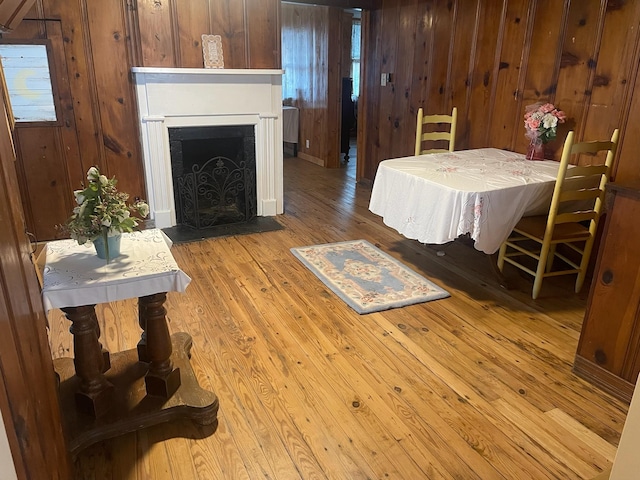 dining space featuring light hardwood / wood-style floors and wood walls