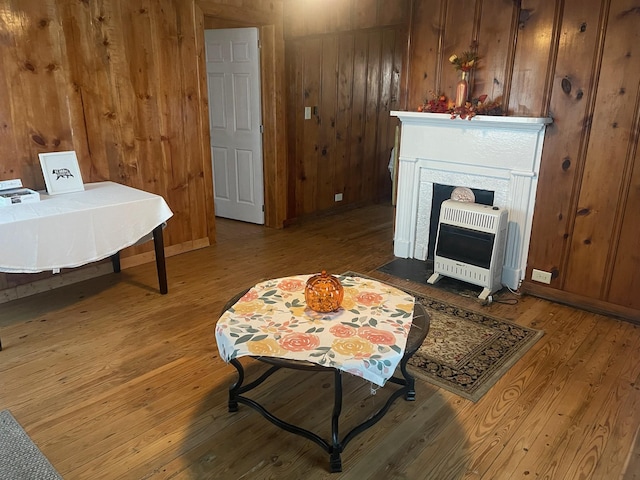 interior space featuring hardwood / wood-style floors, heating unit, and wooden walls