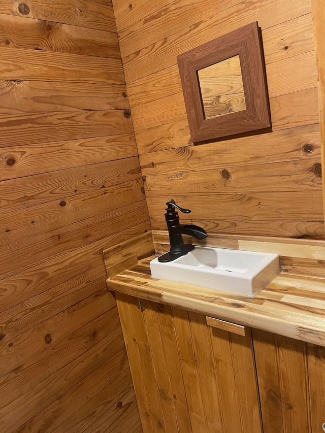 bathroom with vanity and wood walls