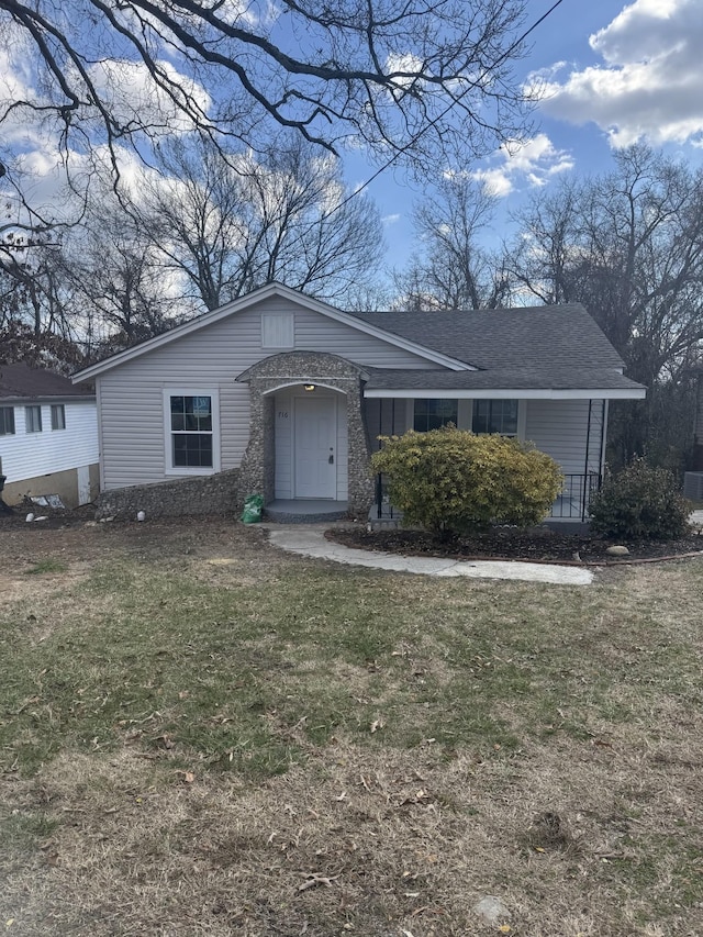 view of front of home with a front yard and a shingled roof