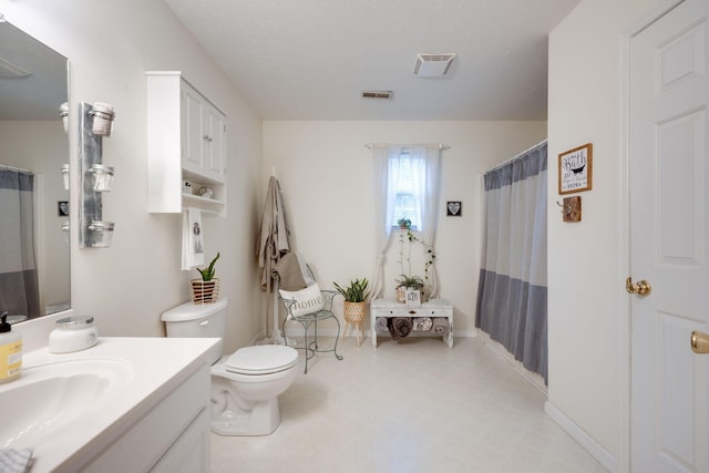 bathroom featuring walk in shower, vanity, and toilet