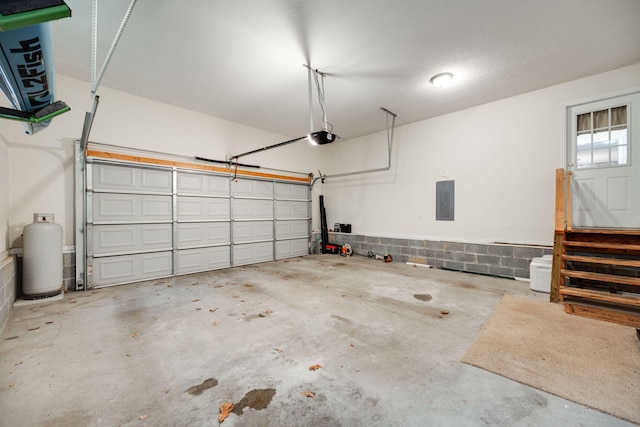 garage with electric panel and a garage door opener