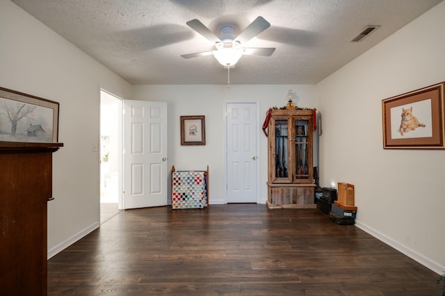 interior space with dark hardwood / wood-style flooring, a textured ceiling, and ceiling fan