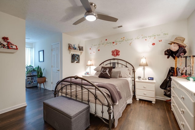 bedroom featuring dark wood-type flooring, a textured ceiling, and ceiling fan