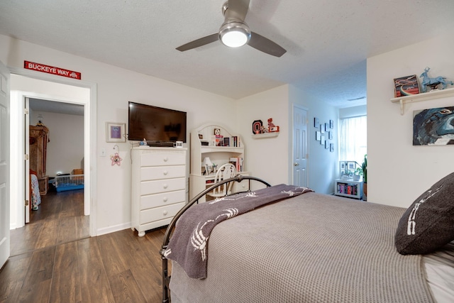 bedroom with ceiling fan, a textured ceiling, and dark hardwood / wood-style flooring