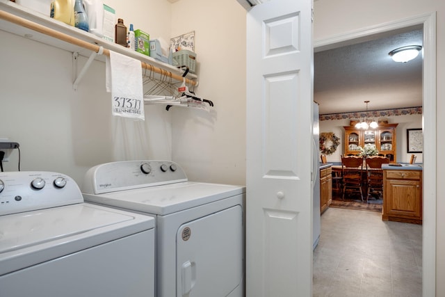 washroom with an inviting chandelier, independent washer and dryer, and a textured ceiling