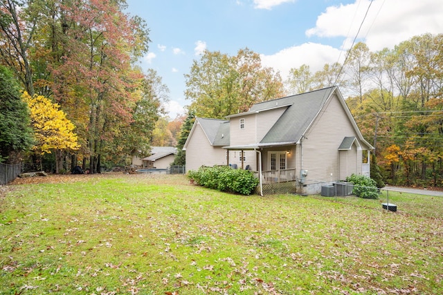 back of house with a lawn and central AC