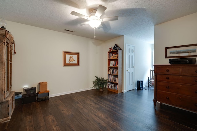 miscellaneous room with ceiling fan, a textured ceiling, and dark hardwood / wood-style floors