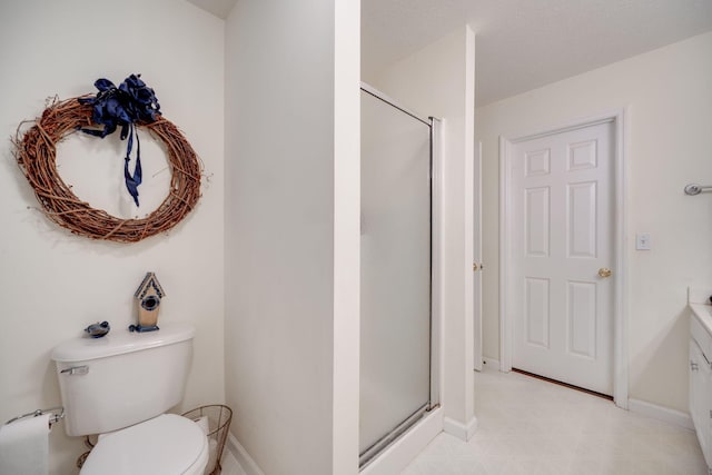 bathroom featuring vanity, toilet, and a shower with door