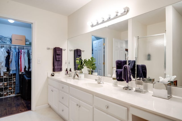 bathroom featuring hardwood / wood-style flooring, vanity, and walk in shower