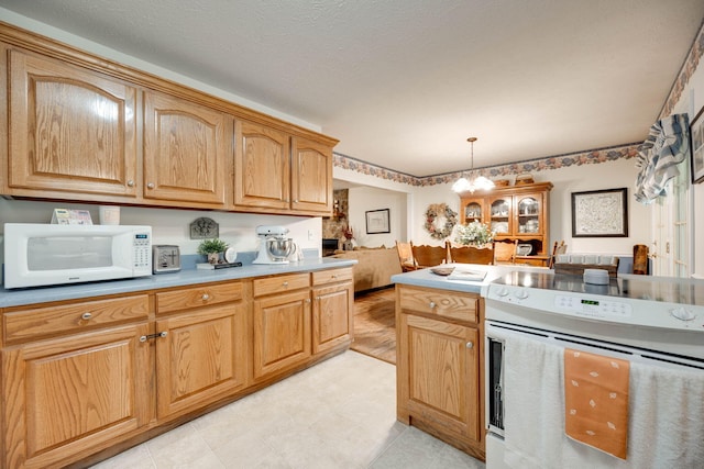 kitchen with a chandelier, white appliances, and decorative light fixtures