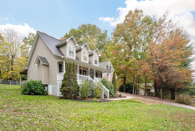 view of side of property featuring a yard and covered porch