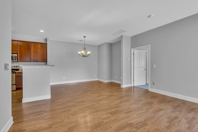 unfurnished living room featuring light wood-type flooring and a notable chandelier