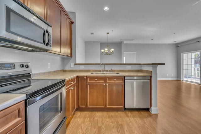 kitchen featuring light hardwood / wood-style floors, stainless steel appliances, sink, a chandelier, and decorative light fixtures