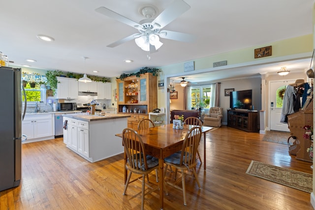 dining room with ceiling fan, light hardwood / wood-style floors, and sink