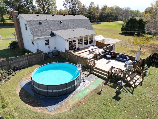 view of pool featuring a lawn, central air condition unit, and a patio