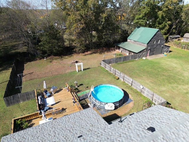 view of swimming pool with an outbuilding, a deck, and a lawn