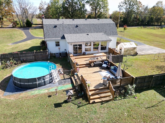 view of pool featuring a lawn and a deck