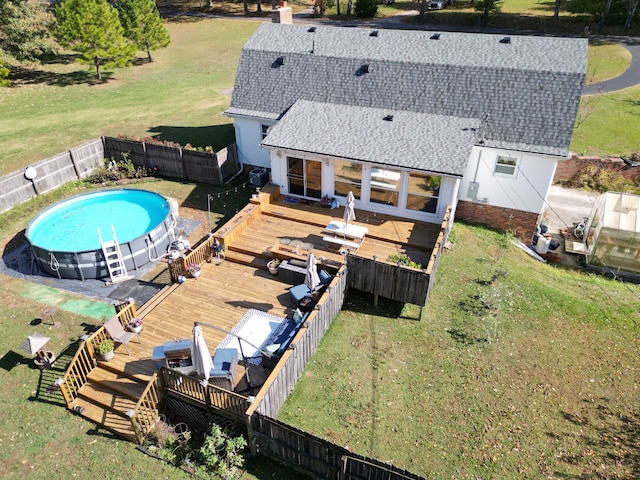 view of pool with a lawn and a deck