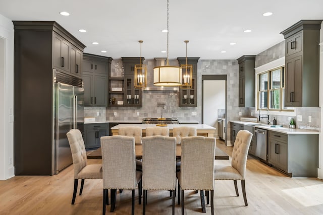 dining room featuring light wood-type flooring, sink, and a chandelier