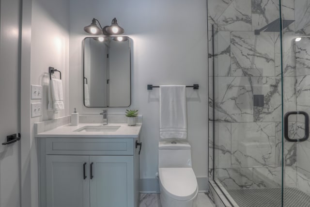 bathroom featuring toilet, vanity, and a shower with shower door