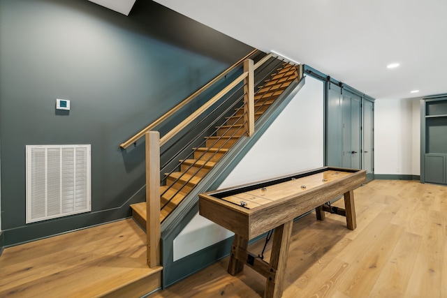 staircase with wood-type flooring and a barn door