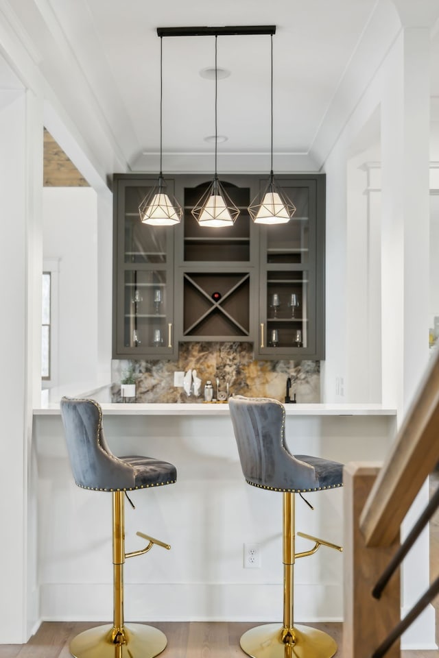 bar with hardwood / wood-style floors, decorative light fixtures, and decorative backsplash