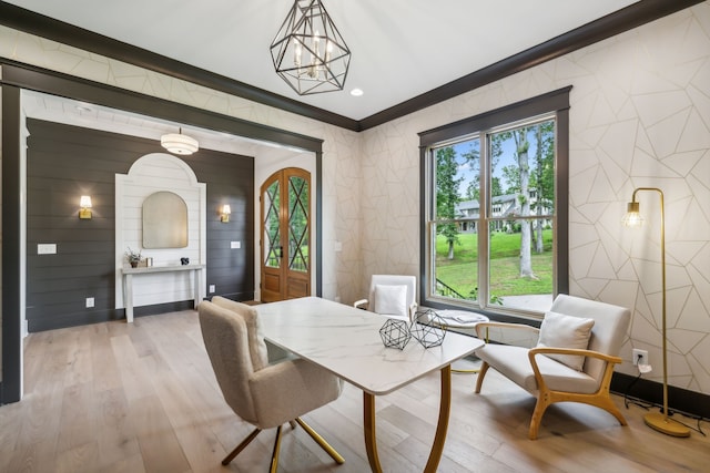 dining space featuring ornamental molding, a chandelier, and light hardwood / wood-style floors