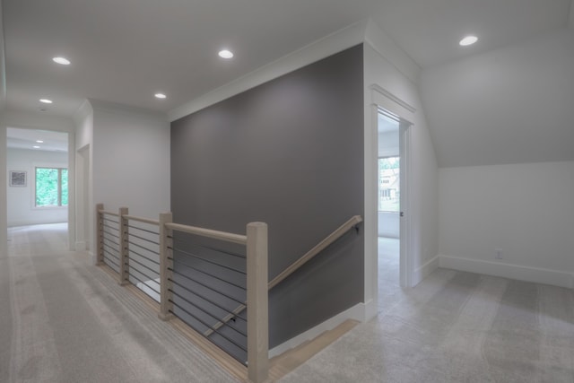 corridor featuring vaulted ceiling and light colored carpet