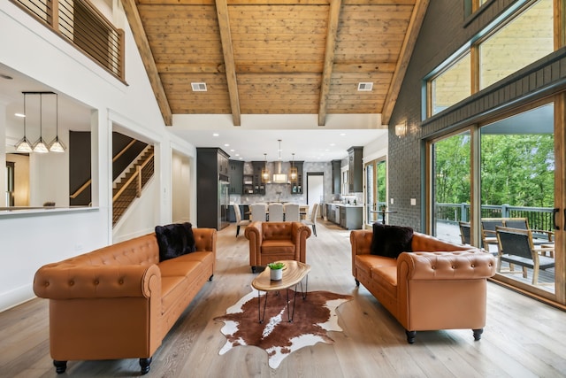 living room featuring high vaulted ceiling, light hardwood / wood-style flooring, wood ceiling, and beam ceiling