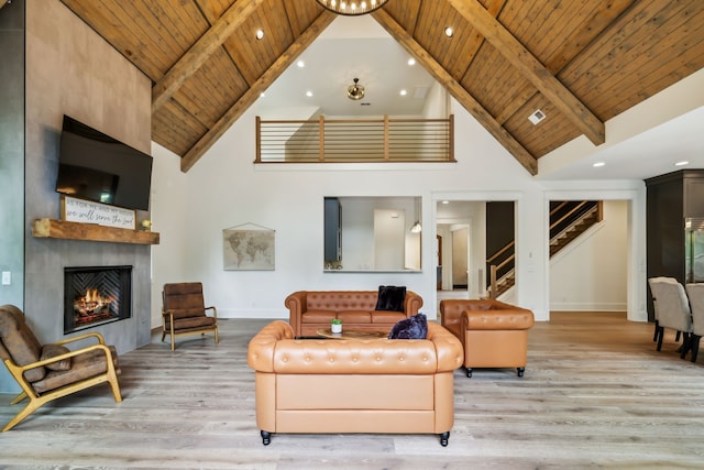 living room featuring beamed ceiling, a large fireplace, high vaulted ceiling, wood-type flooring, and wood ceiling