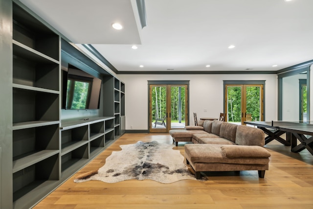 living room with french doors, light wood-type flooring, and crown molding