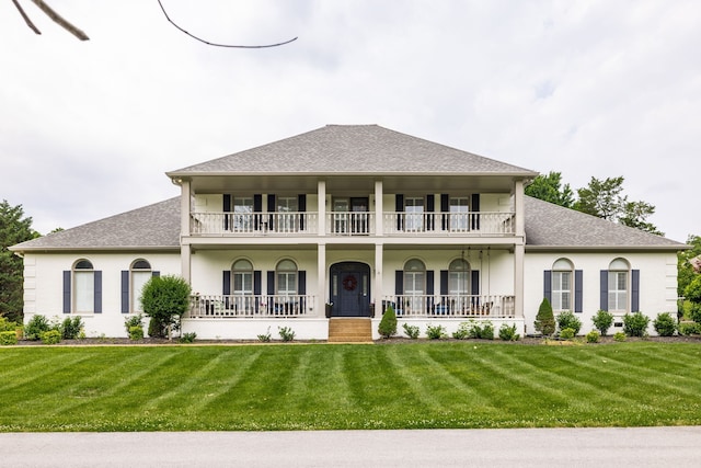 view of front of property with a porch, a front yard, and a balcony