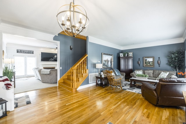 living room featuring an inviting chandelier, hardwood / wood-style floors, and ornamental molding