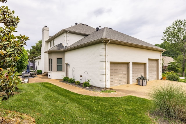 view of side of property featuring a garage and a lawn