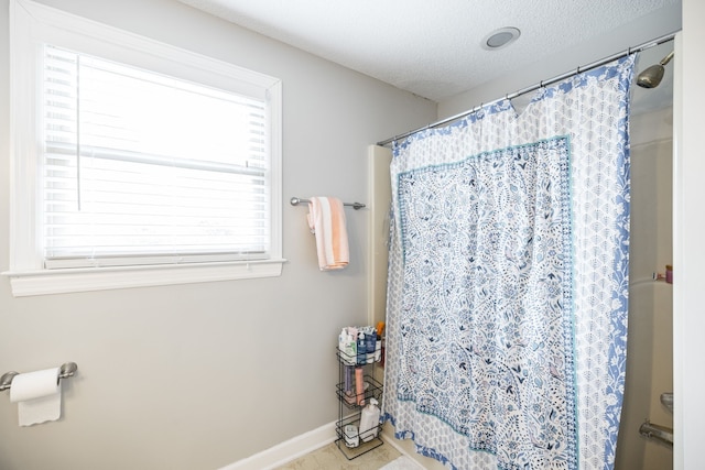 bathroom with tile patterned floors, a textured ceiling, and curtained shower