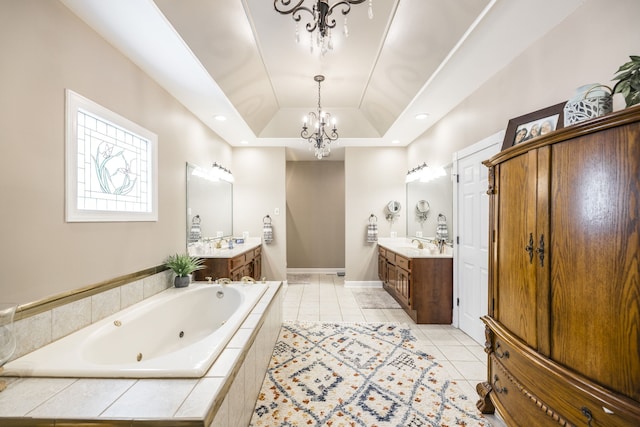 bathroom featuring a relaxing tiled tub, a tray ceiling, a chandelier, vanity, and tile patterned floors