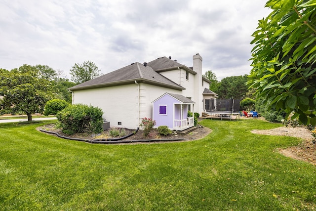 view of property exterior with a lawn and a trampoline