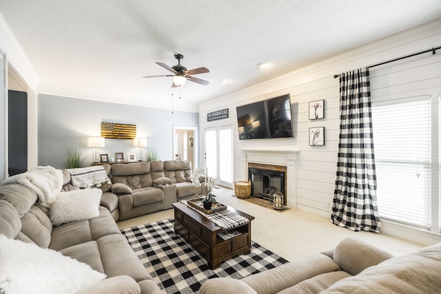 living room with wood walls, a wealth of natural light, light colored carpet, and ceiling fan