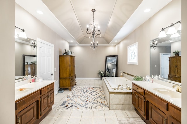 bathroom with vanity, tile patterned floors, a raised ceiling, and tiled tub