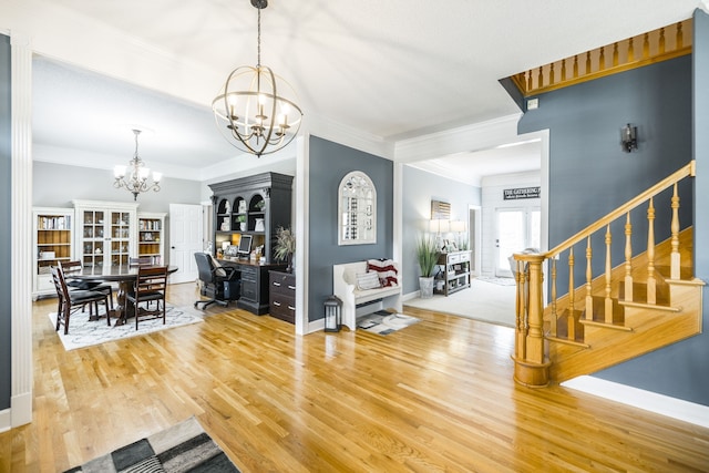 foyer entrance with hardwood / wood-style floors, a notable chandelier, and crown molding