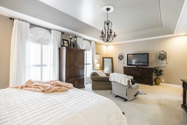 carpeted bedroom featuring a chandelier, a tray ceiling, and multiple windows