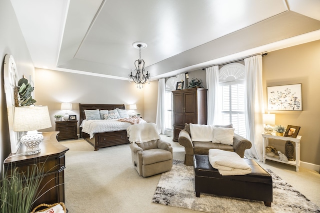 carpeted bedroom featuring a notable chandelier and a raised ceiling