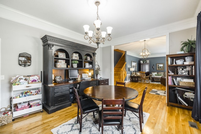 dining room with ornamental molding, hardwood / wood-style floors, and a chandelier